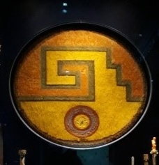 Xicalcoliuhqui īyōllō — The G with a sun-heart — as it sits in the case